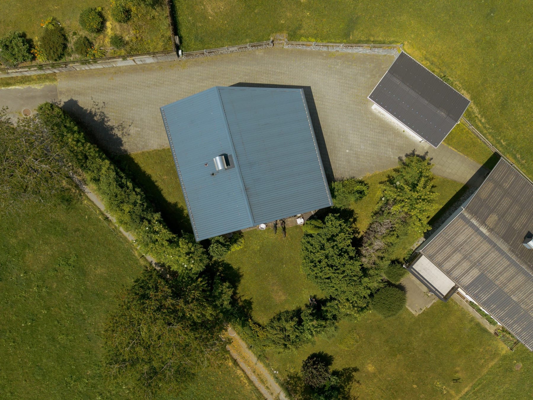 Luchtfoto van de complete kavel met huis, oprit en schuur